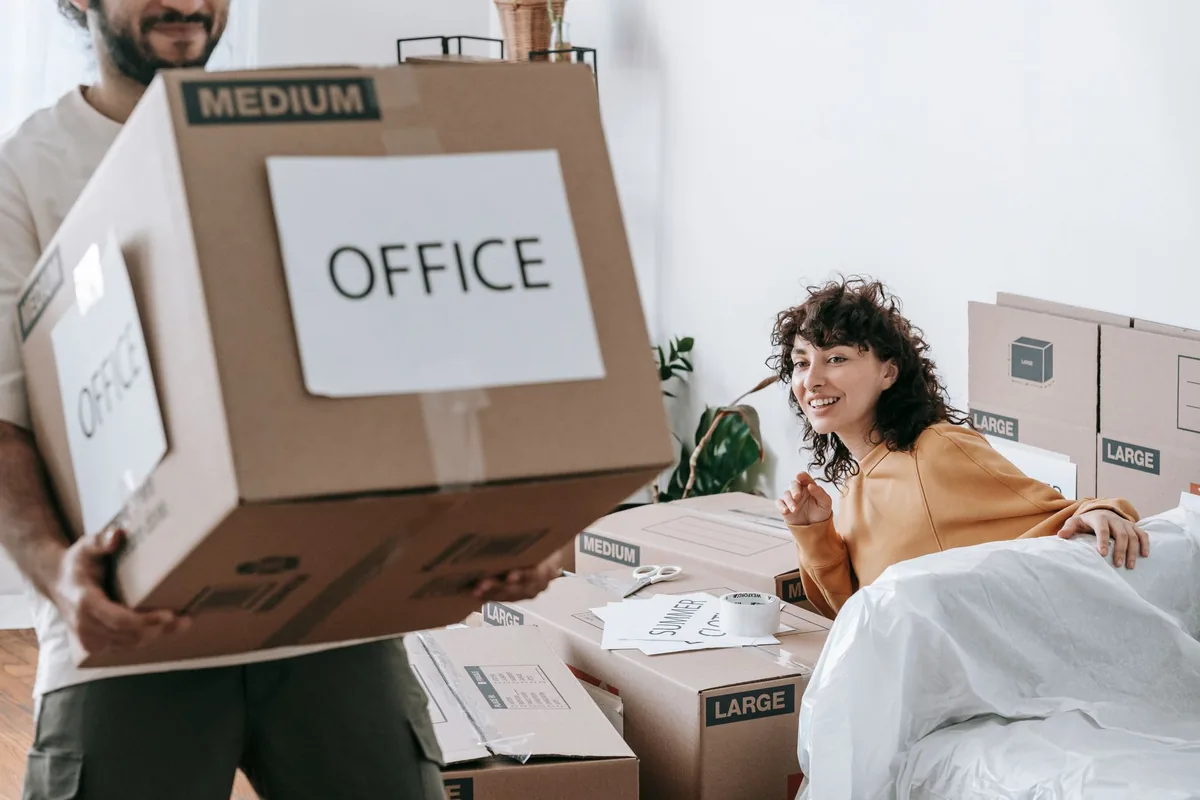 Beschriftete Bürokartons stehen an einem Arbeitsplatz zum Abtransport bereit