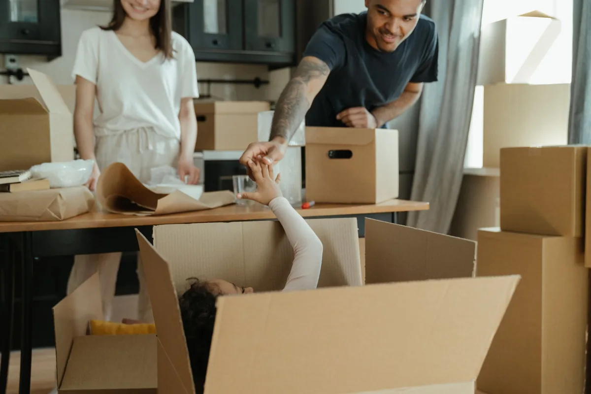 Mehrere Kartons werden in einem Wohnraum systematisch gepackt