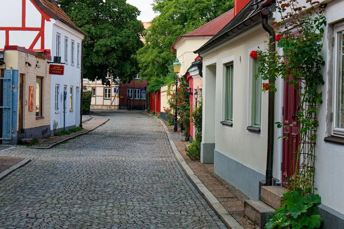 Eine ruhige gepflasterte Straße führt an niedrigen Wohnhäusern vorbei